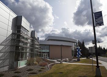 modern college building facade with clouds