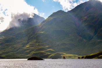 mountains with clouds over a lake