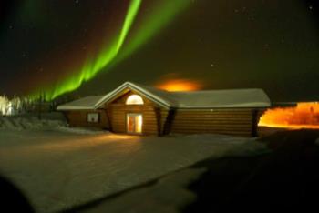 aurora borealis above a log cabin