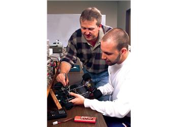 two men working with electronics