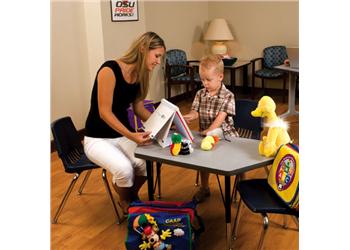 woman and child at table with educational toys